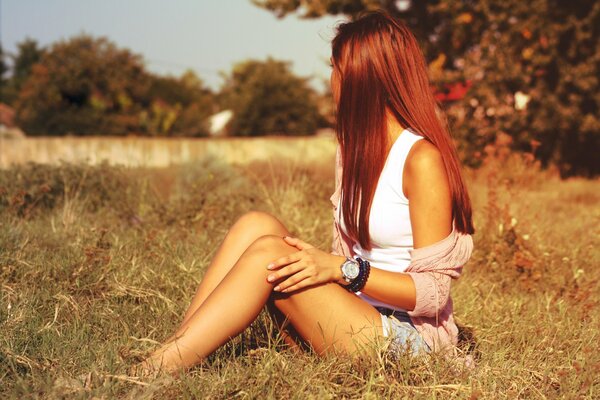 Fille assise sur l herbe au milieu du champ