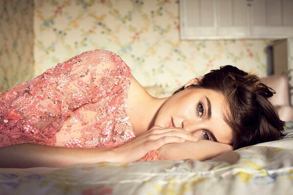 Shailene Woodley is lying on the bed