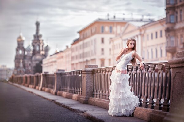 A girl in a wedding dress on the background of a street in St. Petersburg