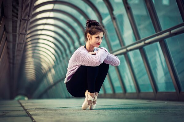 Ballerine fille dans le tunnel de verre sur la pointe des pieds