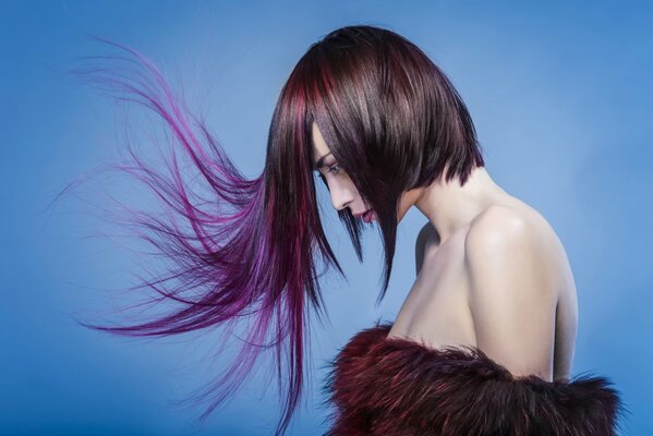 A girl with an extravagant hairstyle stands in profile