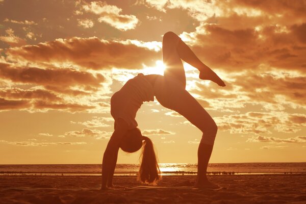 Gimnasta chica haciendo en la playa