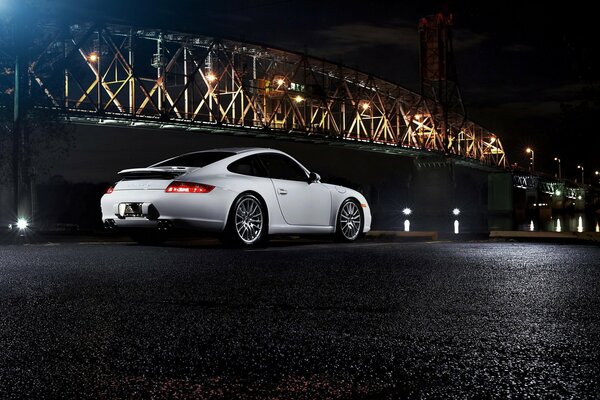 Blanc porsche 911 carrera dans la nuit près du pont