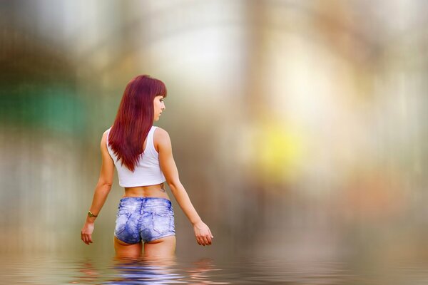 Mädchen in kurzen Shorts und weißem T-shirt Tische im Wasser