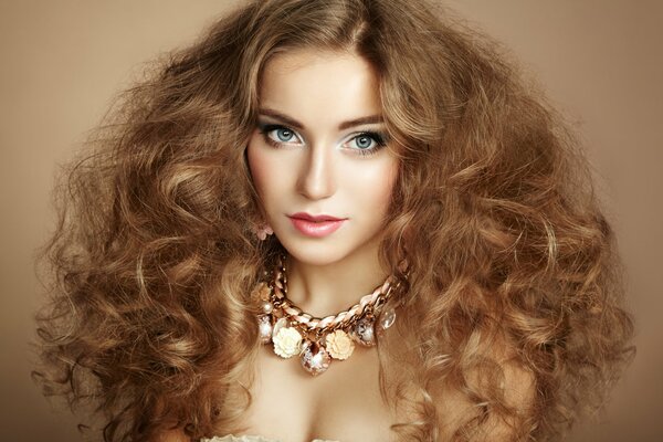 A model girl with curly hair and a neck ornament