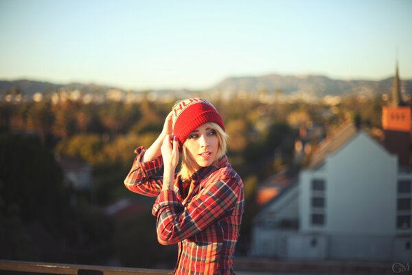 A girl in a red hat on the background of the city