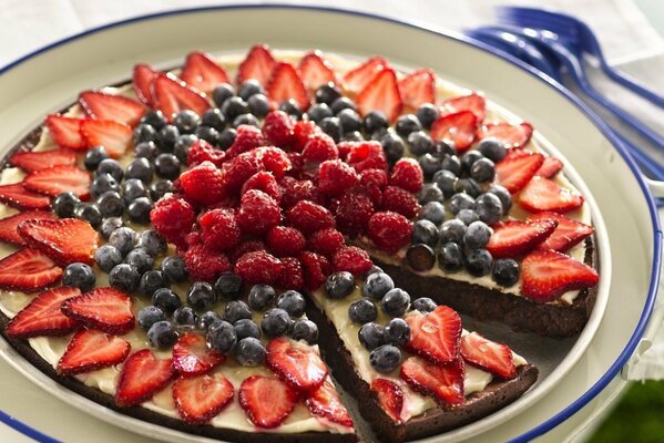 Pastel en un plato con arándanos, fresas y frambuesas