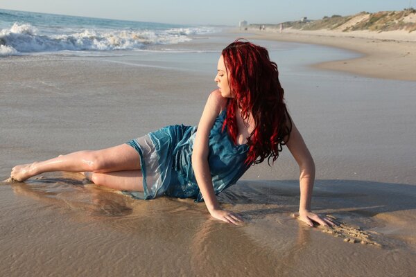 Hermosa chica de pelo rojo en la playa