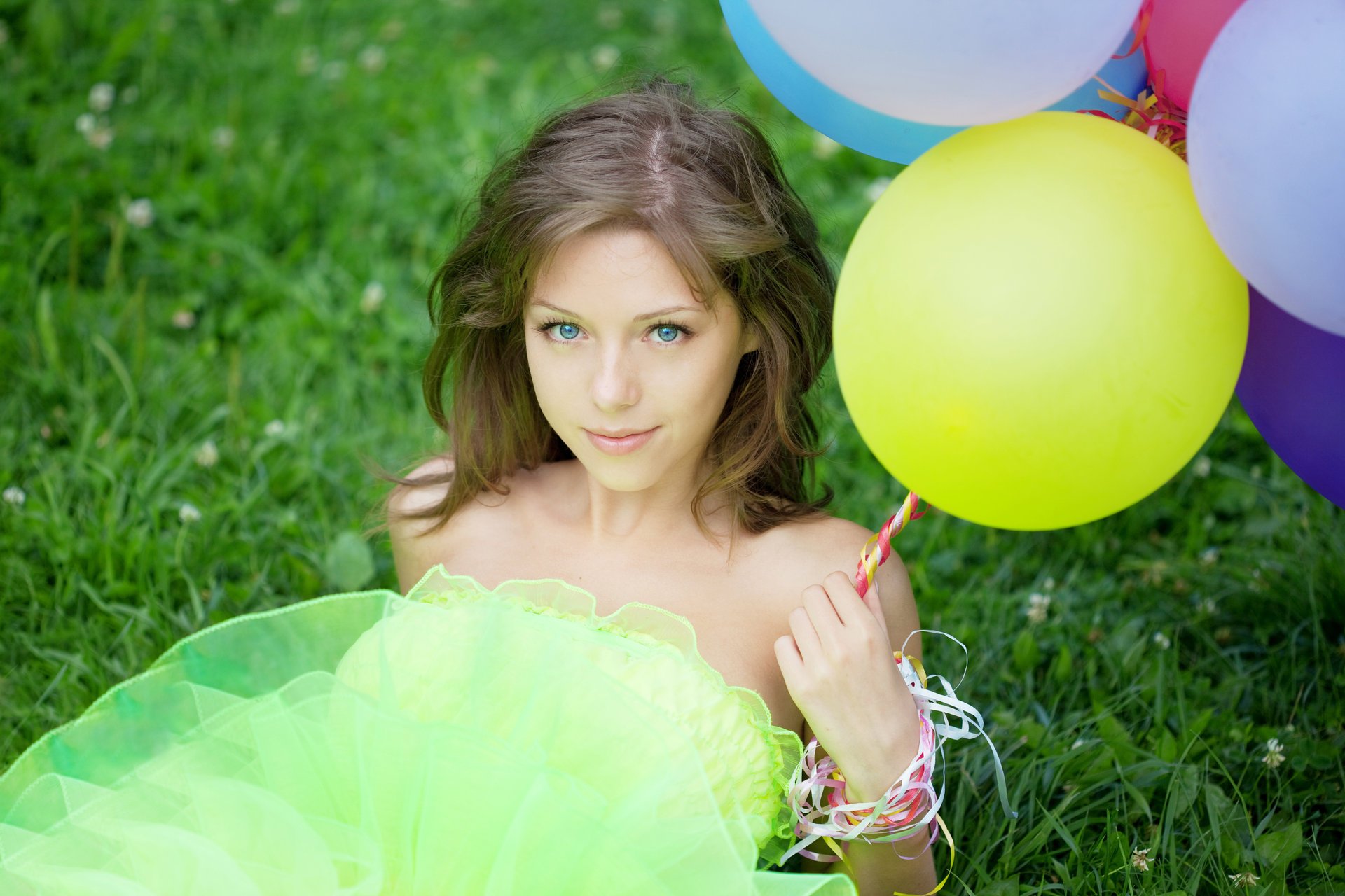 girl blue eyes brown hair balloons grass clover view . smile lock