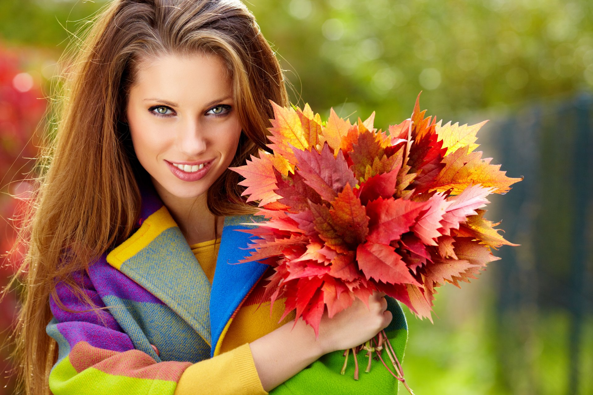 fille aux yeux verts aux cheveux bruns cheveux longs sourire manteau feuilles bordeaux automne