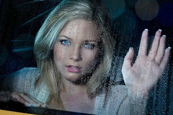Seduto in macchina e fuori la pioggia sul finestrino bussa