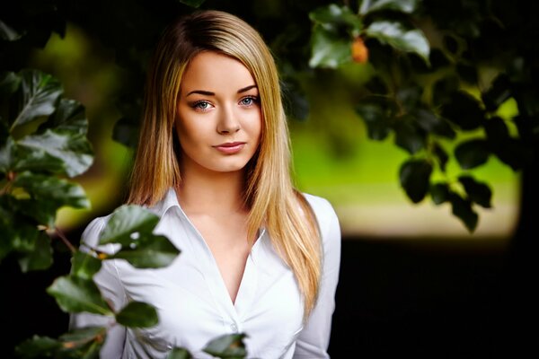 Porträt einer schönen Blondine im Garten