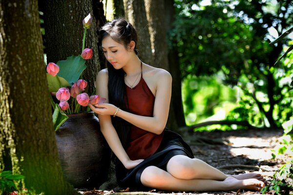 Asian girl near a tree with flowers