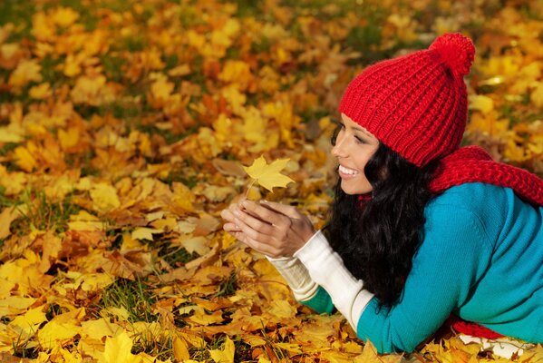 Sesión de fotos de otoño con una chica en las hojas