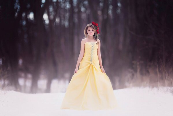 Chica en un hermoso vestido amarillo en el fondo del bosque