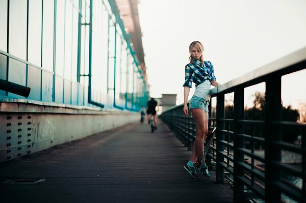 Chica delgada en el puente de la ciudad