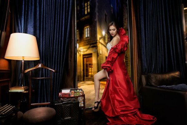 Mädchen in einem leuchtend roten Peignoir im Zimmer