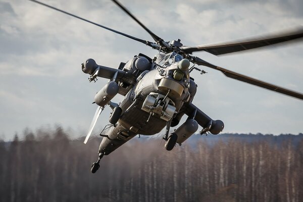 Flying helicopter in flight over the trees