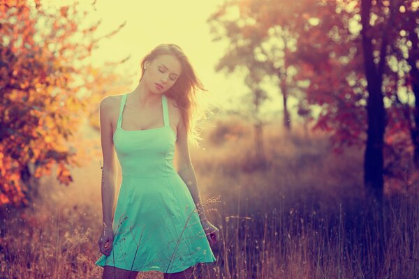 Ragazza in un breve prendisole blu nel campo