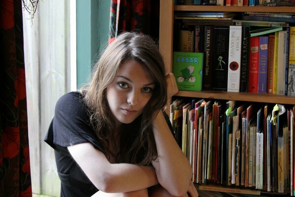 A young girl on the background of a home library