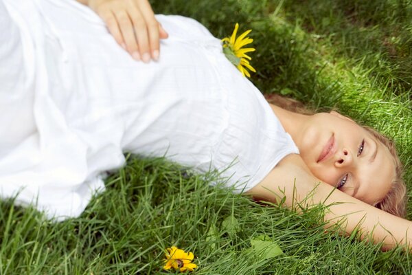 Jeune fille se trouve sur l herbe dans une robe blanche