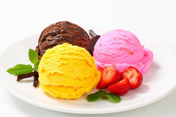 Boules de crème glacée multicolores sur une assiette avec des fraises