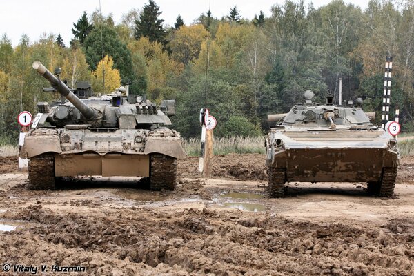 BMP - 2 y T-80U en el relleno sanitario en el barro cerca del bosque