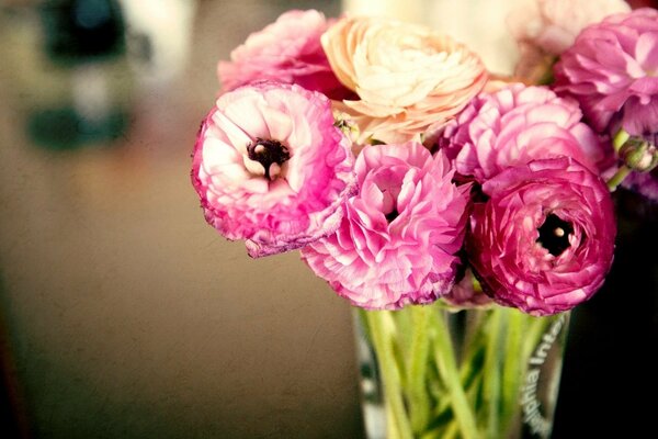 Rosebuds of buttercups in a transparent vase