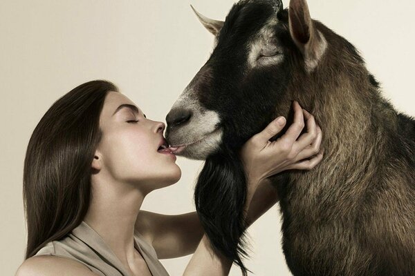 Kiss of a girl with a horned goat