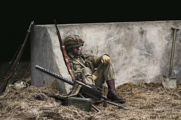 Ein müder Soldat hinter den Barrikaden mit einem Pulimet