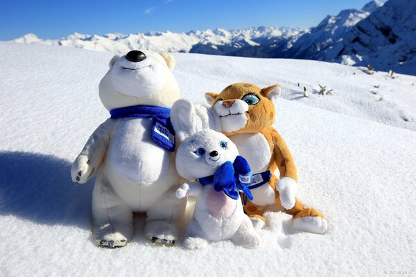 Mascotas olímpicas en la montaña blanca como la nieve