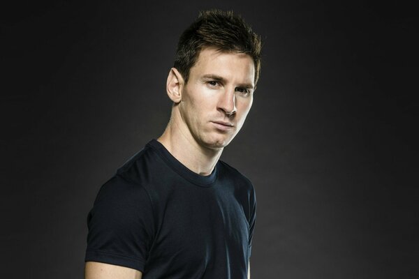 Footballer Messi in a stylish black T-shirt on a black background