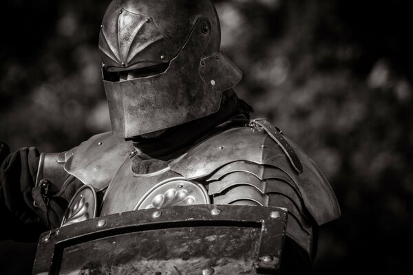 A warrior in armor wearing a helmet with a shield