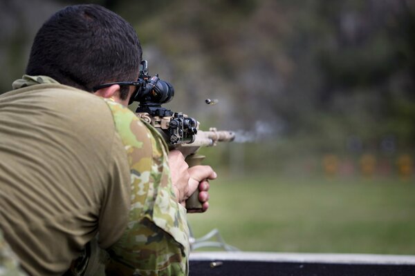 An army soldier shoots at a target