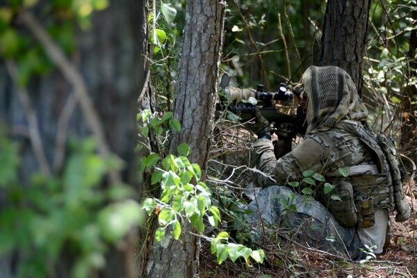 Soldat déguisé avec des armes dans la forêt