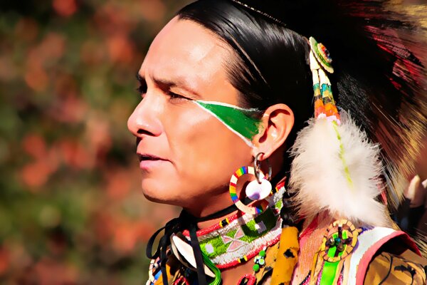 An Indian man with feathers and a painted face