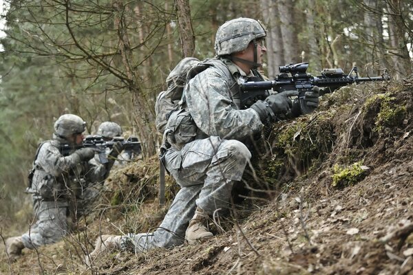 Soldaten mit Waffen in der Hand unter Bäumen