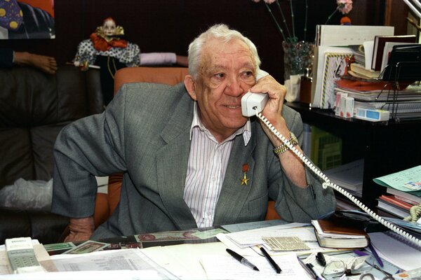 Yuri Nikulin talking on the phone in his office