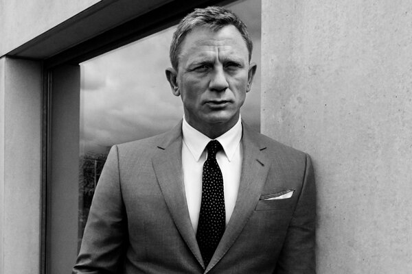Daniel Craig dans un costume avec une cravate. Photo noir et blanc