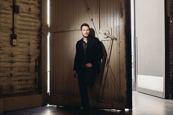Chris Pratt en la puerta del granero con una chaqueta negra