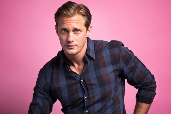 Alexander Skarsgard in a shirt on a pink background