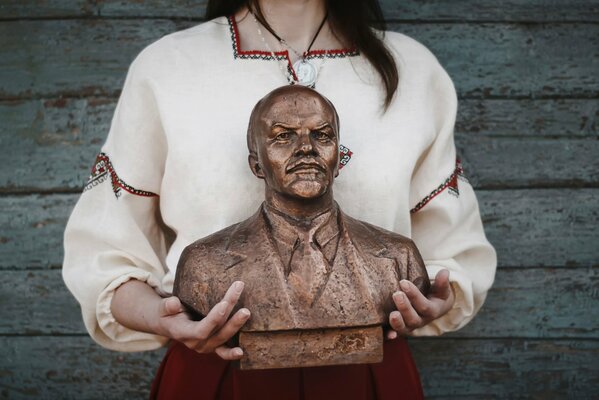 The girl holding the bust of the leader