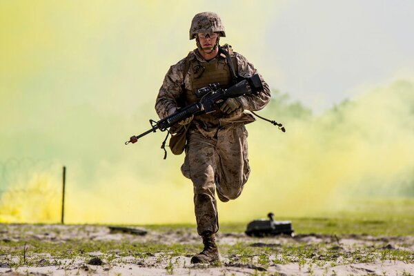 Солдат с оружием бежит на фоне дыма
