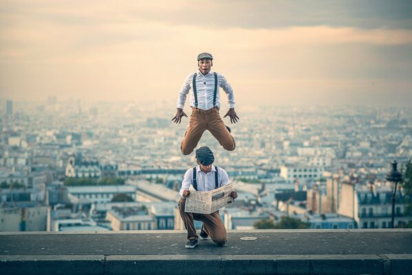 Dancing man with a newspaper bounces in the city