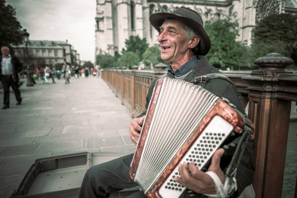 An old musician is playing on the street