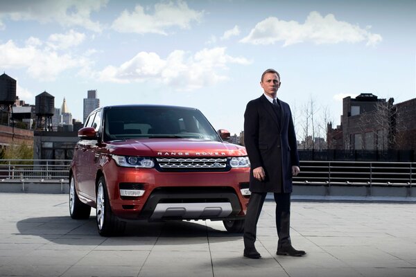 Daniel Craig as James Bond next to the car