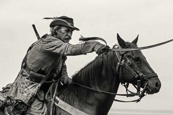 A man in a hat with a saber on a horse