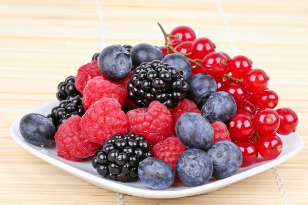 Plato de bayas con grosellas, moras, frambuesas y arándanos