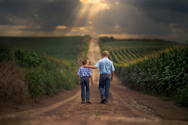 Sohn und Vater gehen durch landwirtschaftliche Felder