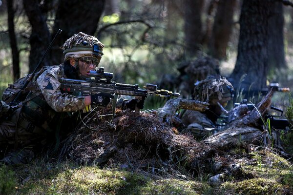 Soldaten sitzen mit Waffen in einem Hinterhalt